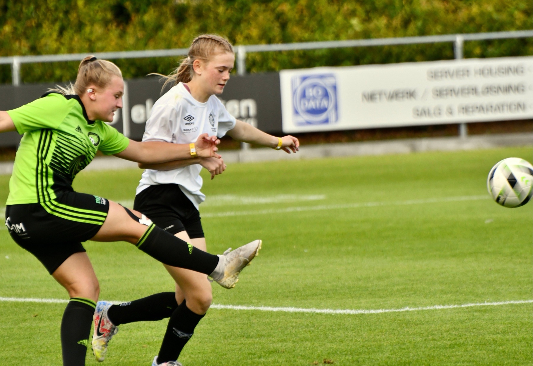Två unga fotbollsspelare kämpar om bollen under en match